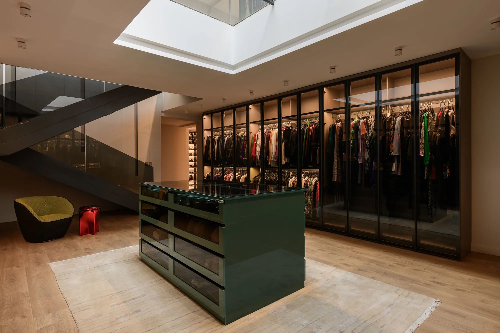 Glass-fronted walk-in wardrobe with central island, Palm Hills Residence by Modoro